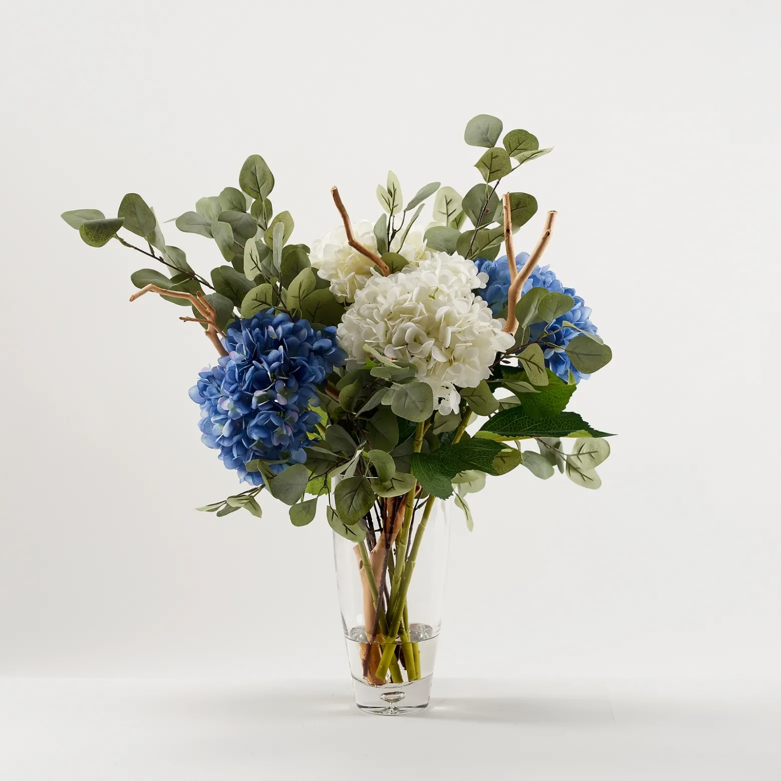 Cream and Blue Hydrangeas with Eucalyptus in Clear Glass Vase